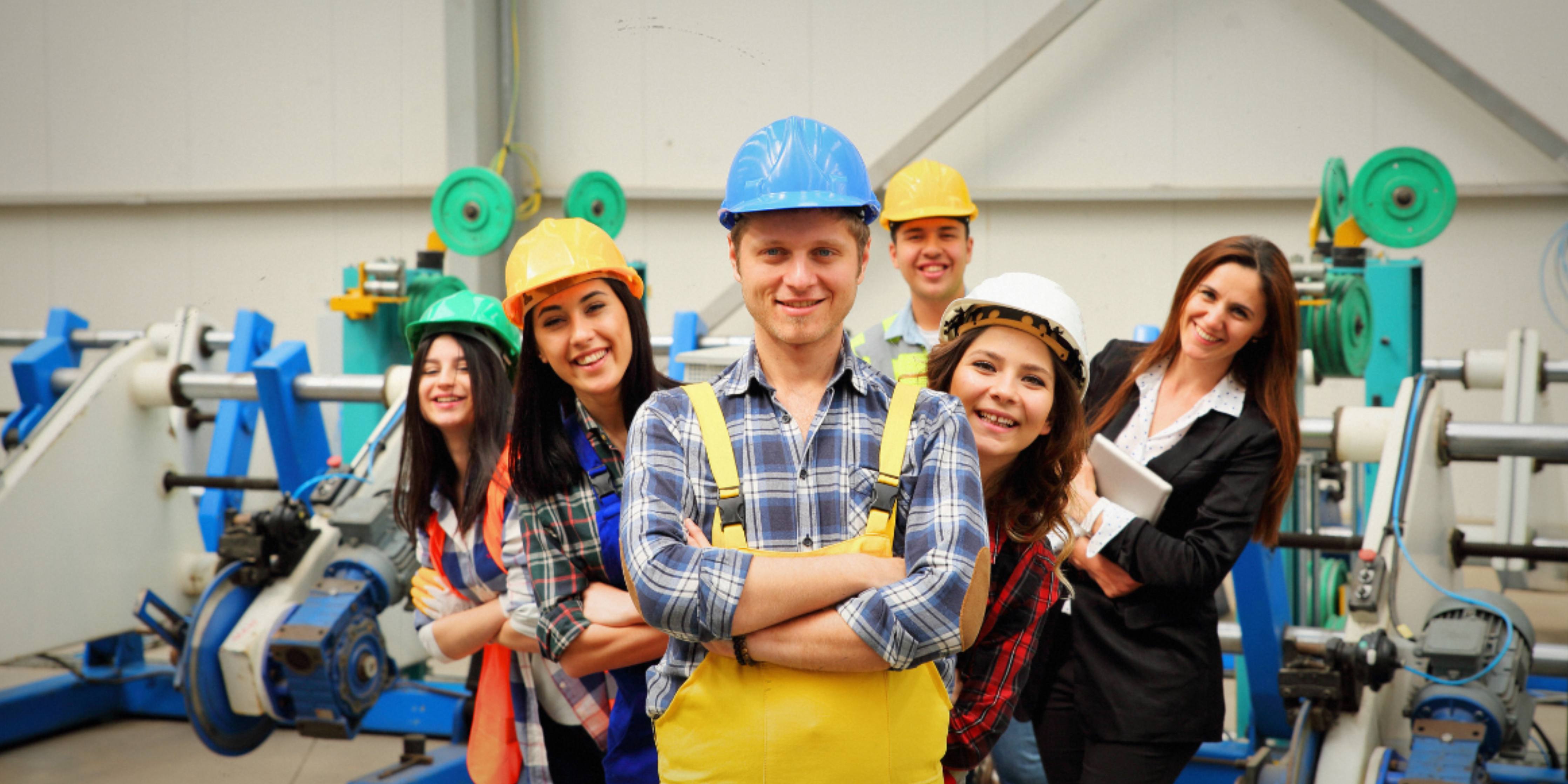 Group of people in a factory setting with safety gear