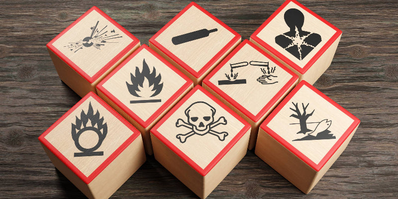 Wooden blocks showing different symbols of chemical hazard warnings on wood table. Illustration of the concept of toxic substances and occupational health