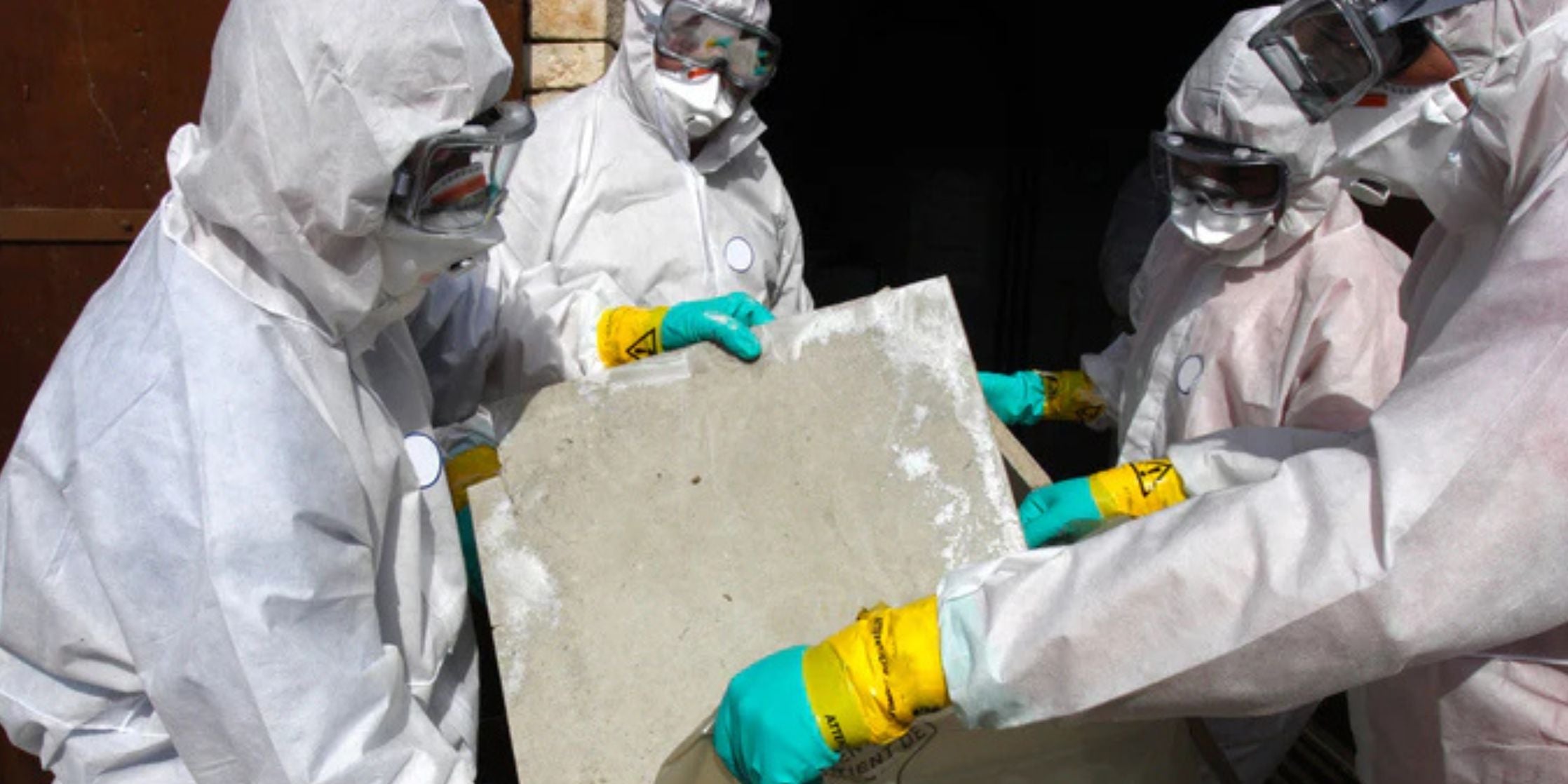 Staff removing materials containing some asbestos
