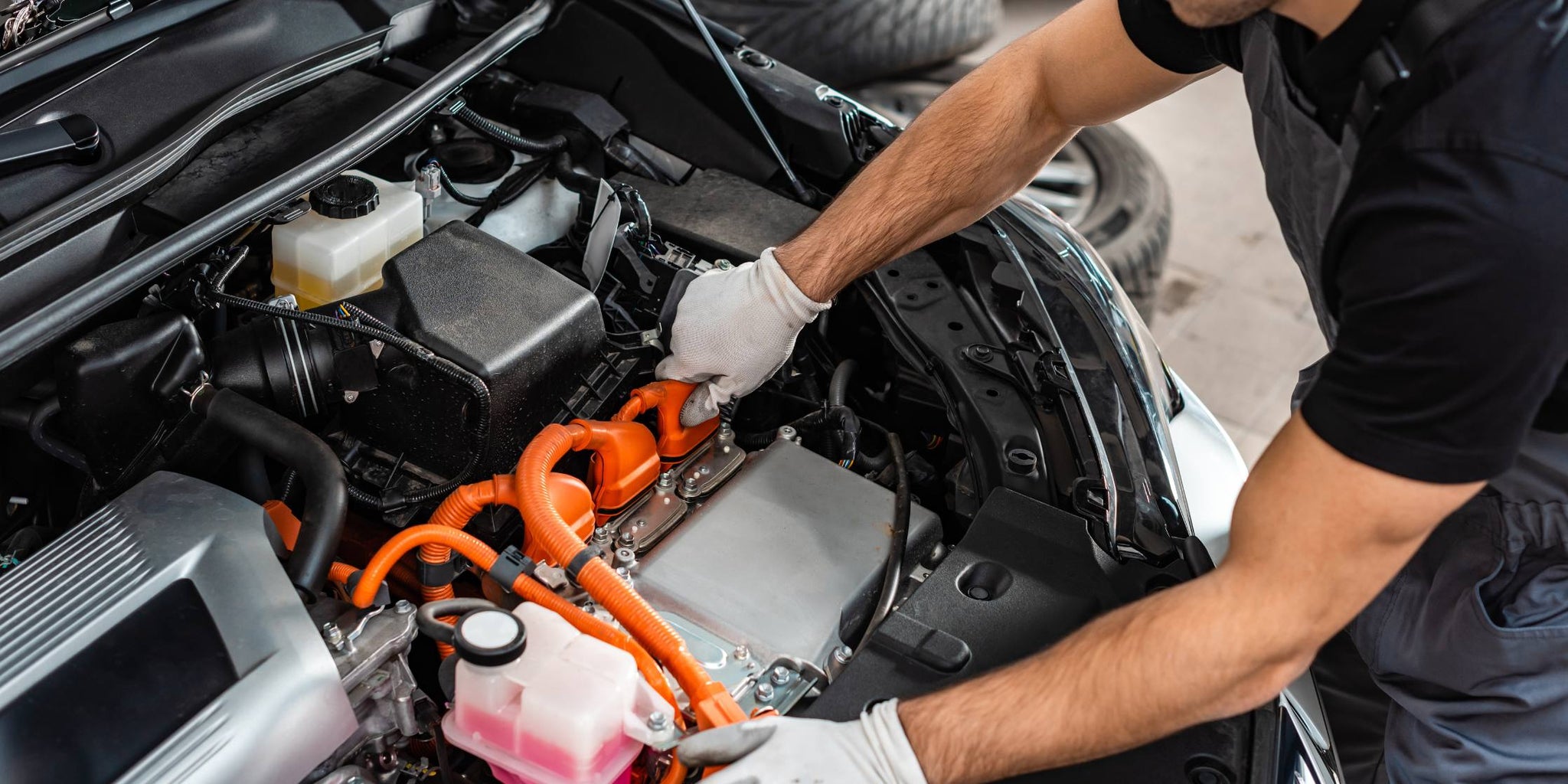 Young mechanic inspecting car engine compartment