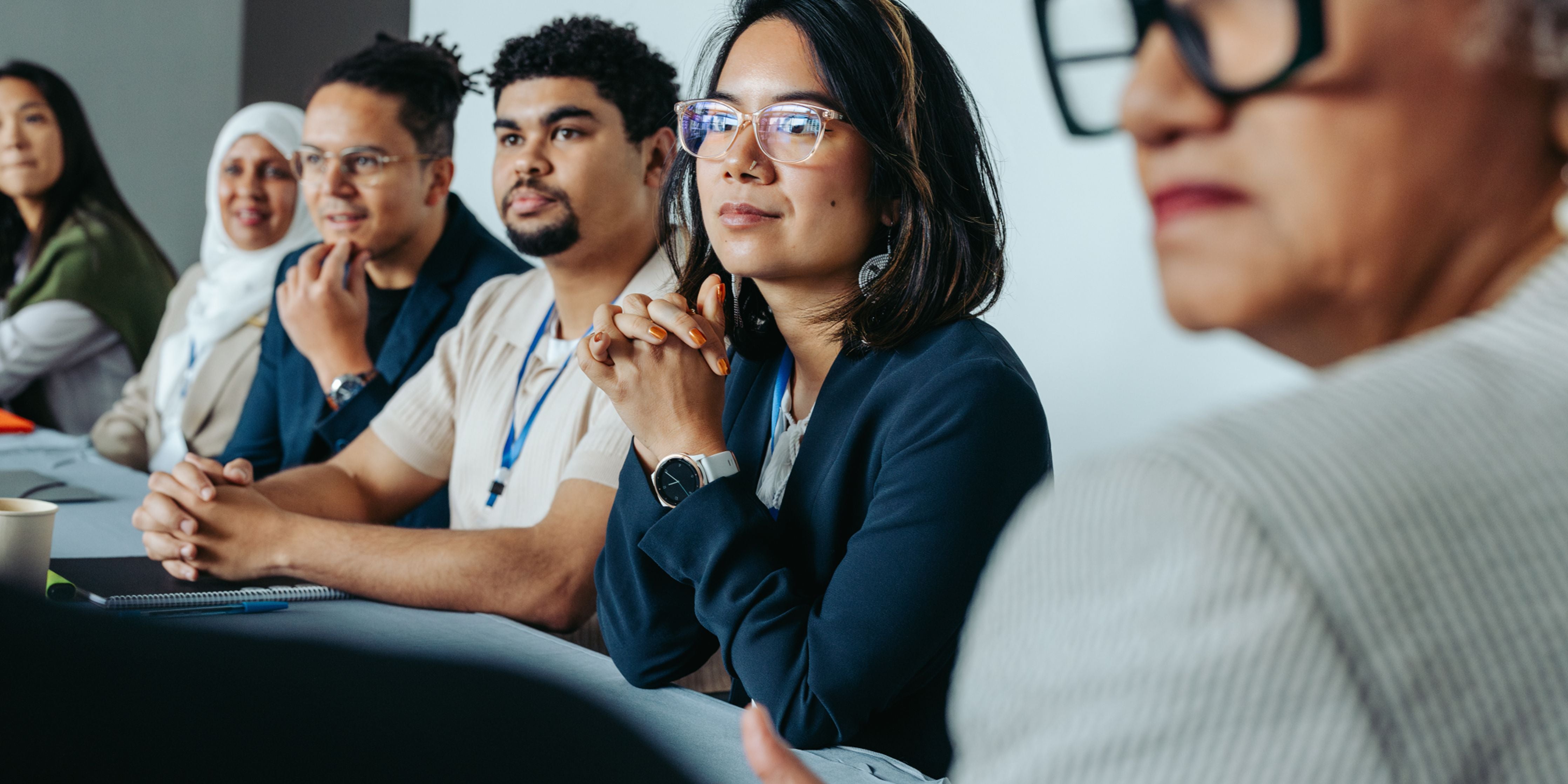 Group of people sitting in a conference room, listening attentively.