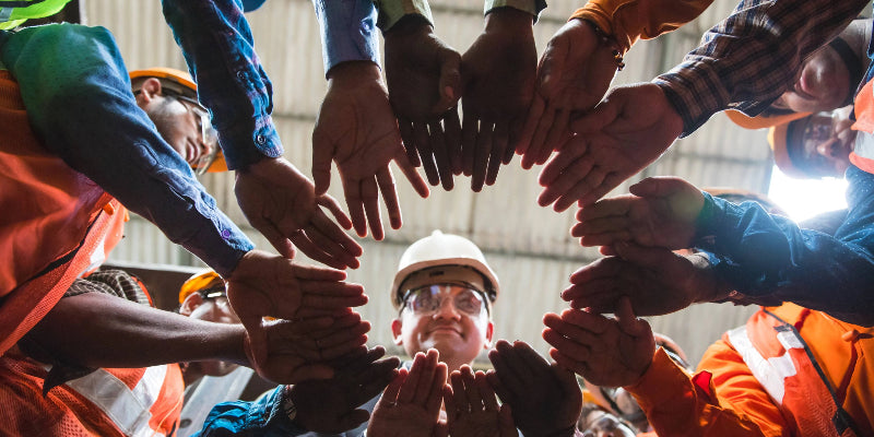 people standing in circle with hands outstretched