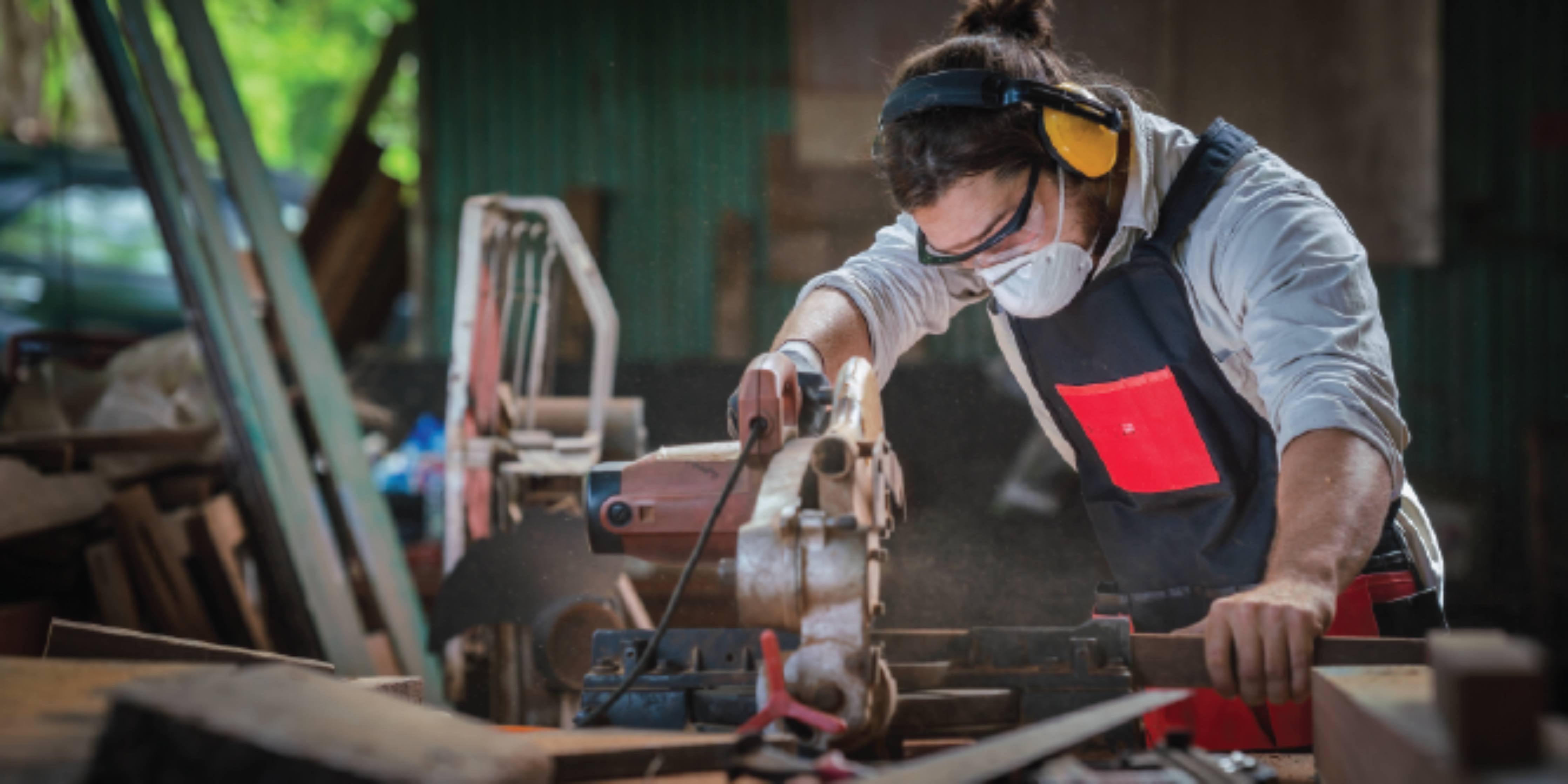 Person using machinery with PPE on to protect from noise in the workplace