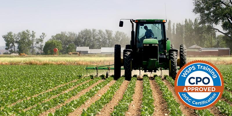 Image of a green tractor plowing through a crop field