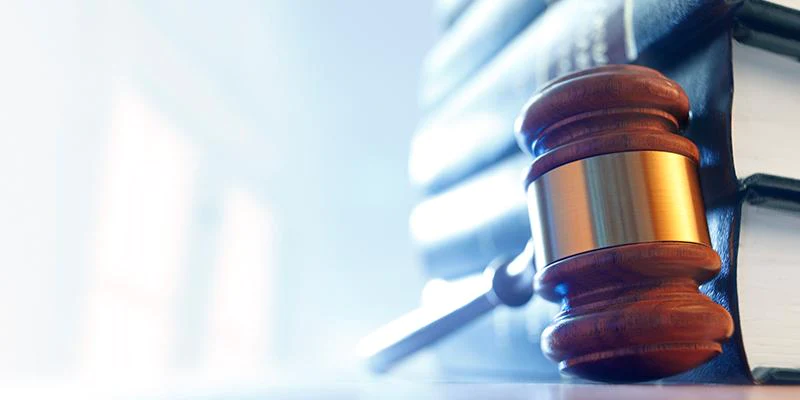 Image of a judge gavel on desk next to stacked books